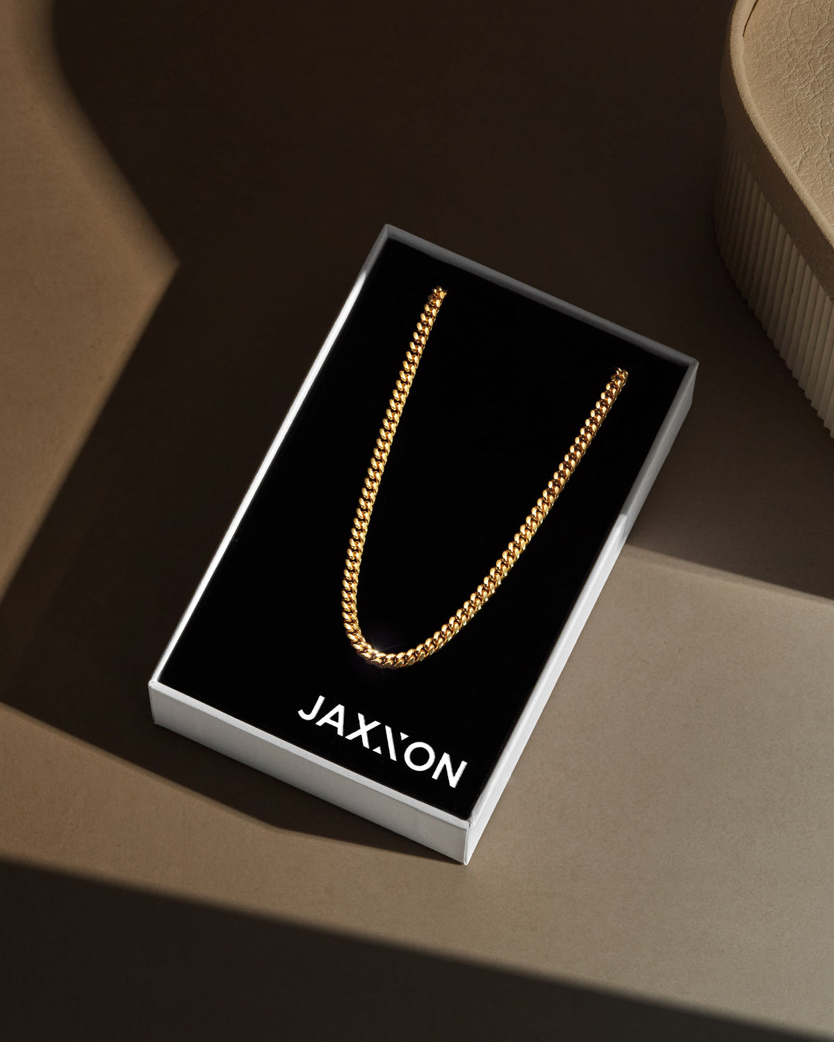 Gold Cuban chain packaged in a black box labeled JAXXON